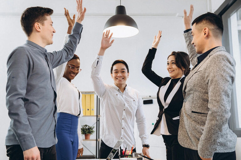 Funcionários de uma empresa celebram os resultados positivos juntos, demonstrando engajamento.