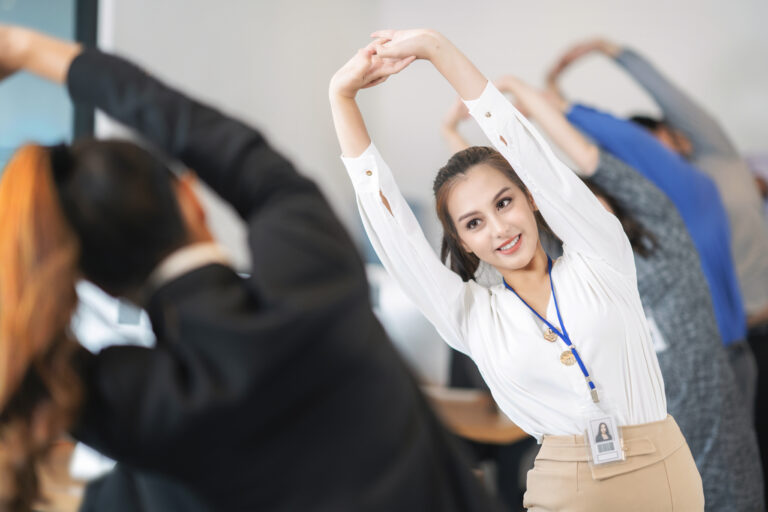 Pessoas alongando em um escritório, buscando bem-estar e saúde nas empresas
