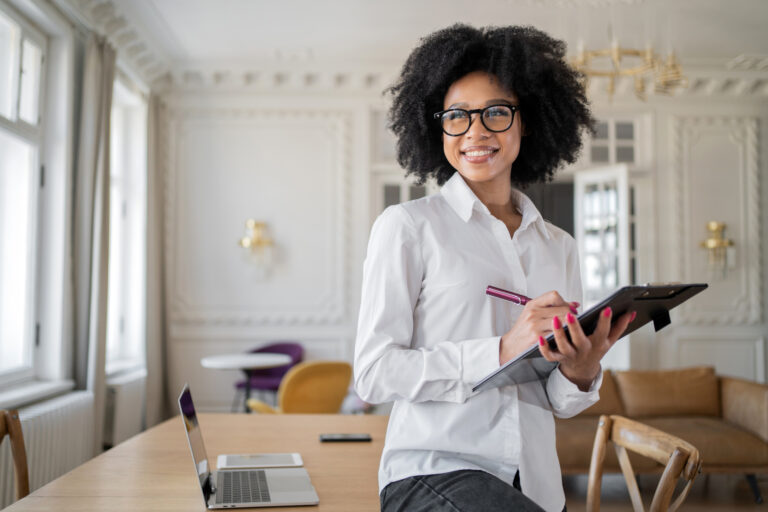Gerente mulher com óculos utiliza tablet no local de trabalho.